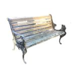 A cast iron garden bench with shaped slatted back & seat, the ends with lions heads and scrolling,