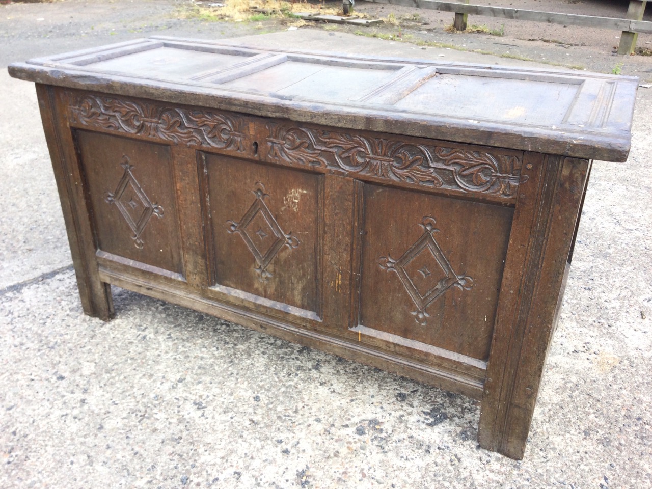 An antique oak coffer with three panels to hinged lid, the front with foliate scroll carved blind - Image 2 of 3
