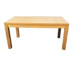 A plain rectangular oak finish dining table raised on thick square column legs. (63in x 35.5in x