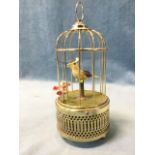 A singing bird automaton, the chirping bird in domed brass cage surmounted by a ring, having