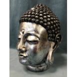 A silvered composition buddha head with noduled hairpiece and long lobbed ears. (13.5in)