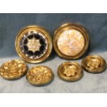Two pairs of decorative brass roundels embossed with flowerheads; and two mother-of-pearl inlaid
