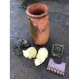 A terracotta tapering chimney pot with tubular rim above a band of roundels; two composition stone