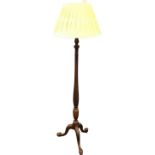 A mahogany standard lamp with pleated shade on fluted turned column carved with wheatear friezes,