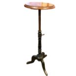 A Victorian adjustable stand with circular moulded oak top on ebonised turned column with tripartite