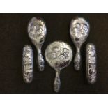 A ladies five-piece silver dressing table set embossed with winged cherubs and entwined scrolled