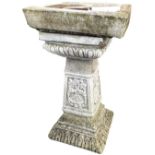 A square composition stone garden birdbath with cushion moulded bowl above lozenge cast collar,