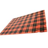 A contemporary tartan rug woven with charcoal and yellow chequered pattern on orange ground. (81in x
