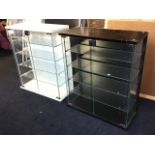A rectangular glass counter display cabinet with hinged doors, having chromed mounts enclosing