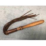 An antique cat-o-nine-tail whip, with leather thongs on turned hardwood handle. (28.5in)