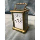 An Edwardian brass carriage clock of architectural form with five bevelled glass panels and