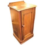 A Victorian walnut pot cupboard with shaped upstand to rounded moulded top, above a panelled door,