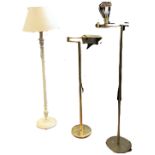 Two modern brass reading lights with hinged adjustable arms holding lamps, the columns on circular