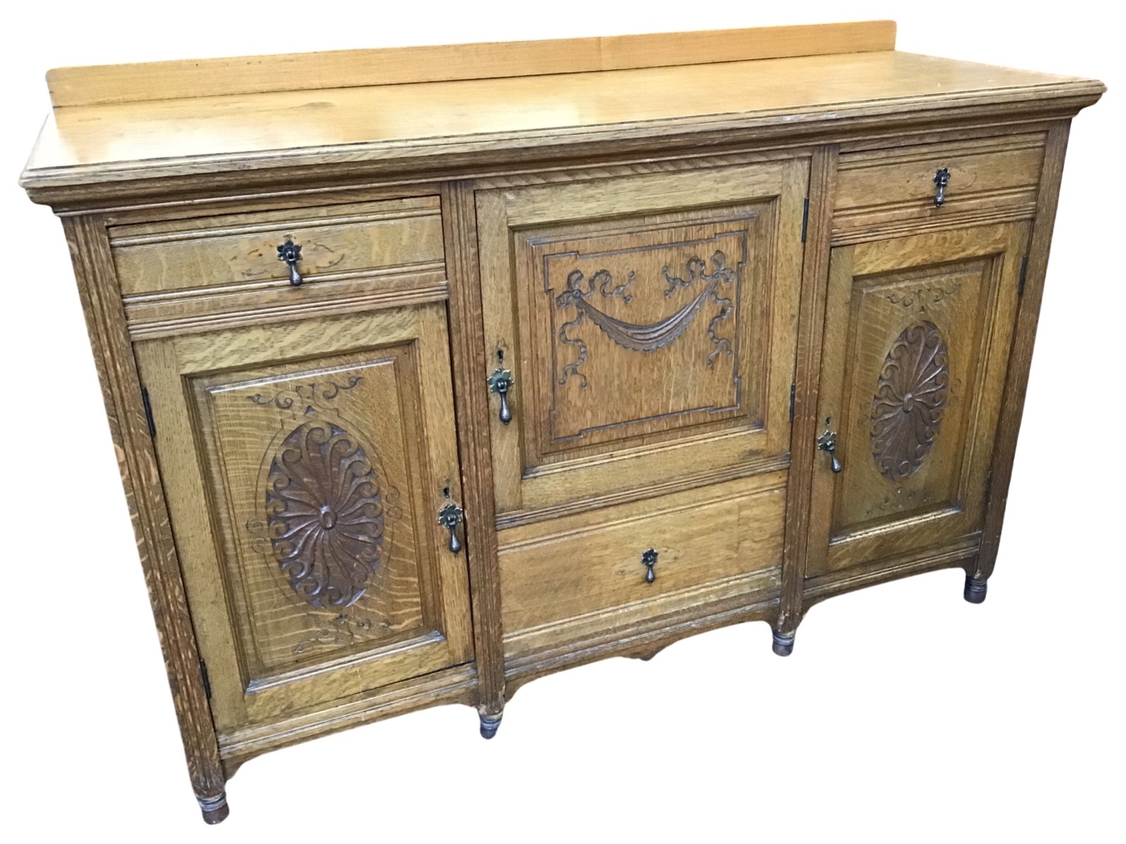 A late Victorian carved oak sideboard, the rectangular moulded top with upstand, above drawers and