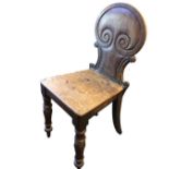 A nineteenth century mahogany hall chair with spade shaped scroll carved back above a tapering seat,