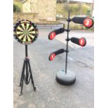 A contemporary Winmau dartboard on telescopic tripod stand with pad feet; and a kick-boxing target