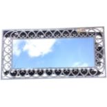 A large 6ft reproduction mirror in painted wrought iron frame, having inlerlaced scrolled heart-