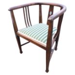 An art nouveau Edwardian oak captains chair with rounded bow arms on side slats and pierced tapering