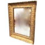 A rectangular mirror in acanthus leaf moulded composition gilded frame, with lozenge & bead inner