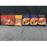 A set of JK Rowling Harry Potter books, three hardbacks with dust covers, and three paperbacks,