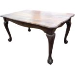A 5ft scalloped mahogany dining table, the rectangular top on shaped rails, supported on tapering