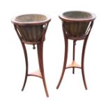 A pair of mahogany jardinière stands with circular ribbed basket frames hung with swagged chains