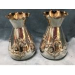 A pair of art nouveau silver plated vases embossed with daffodils to tapering bodies beneath waved