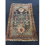 An oriental bokarra rug woven with floral medallions on blue field with serrated edged banded