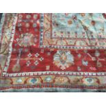 A massive country house Turkey carpet woven with floral motifs on pale green field framed by