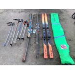 Three pairs of skis, eight ski poles, and a ski travel bag. (A lot)