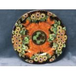 A Maling rack plate decorated with yellow & orange daisies on specked amber ground, the rim with