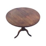 A circular nineteenth century mahogany snap-top occasional table, supported on a turned ribbed
