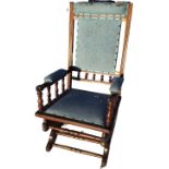 A late Victorian walnut American rocking chair, the upholstered back in moulded ribbbed frame