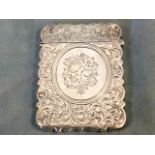 A Victorian hallmarked silver scalloped card case with foliate scrolled decoration and hinged