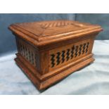A Victorian oak casket with geometric inlaid panels to hinged top and sides, the interior with