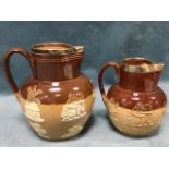 Two Doulton Lambeth stoneware jugs with hallmarked silver mounts, having applied sprigwork
