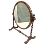 A circular oak dressing table mirror with bevelled plate on barleytwist column supports, with