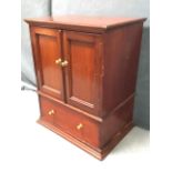 A small Edwardian mahogany tabletop cabinet with hinged cover above brass knobbed panelled doors and