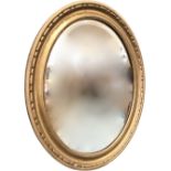 An oval gilt mirror with bevelled plate in lozenge moulded concave frame. (23.5in)