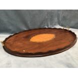 An oval Edwardian mahogany tray with scalloped rim mounted with brass handles, inlaid with boxwood