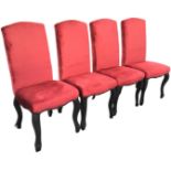 A set of four upholstered dining chairs with high arched backs above cushion seats, raised on