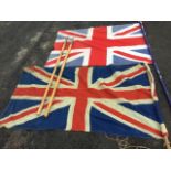 Two old Union Jack flags on poles - stitched linen & printed cotton; and a pair of bamboo shafted