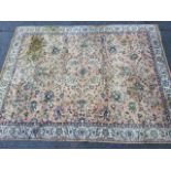A Wilton style carpet, the salmon pink field woven with entwined foliage framed by frieze of
