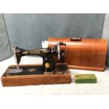 A large domed mahogany cased Singer sewing machine, with turned swing handle. (20in)