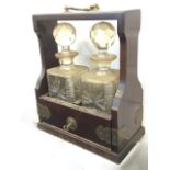A mahogany cased tantalus with pair of square cut glass decanters having ball stoppers, the case