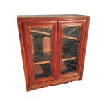 A Chinese hardwood bookcase or display cabinet with cushion moulded glazed doors bordered by pierced