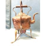 A large oval Victorian copper tea kettle on stand with swing handle, the base with paw feet. (18in)