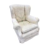 A C20th upholstered wing armchair with loose cushion & covers, the wide sprung seat raised on bun