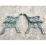 A pair of cast iron bench ends with pierced scrolled decoration to arms, formerly having slats to