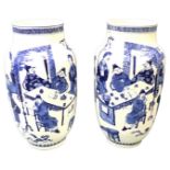 A pair of Chinese blue & white vases decorated with interior scenes having figures around tables,
